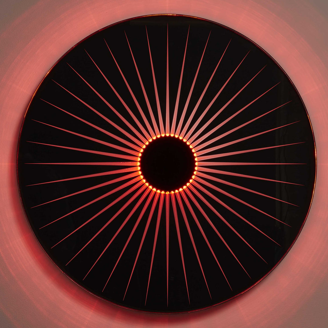 “Iris” by Ben Rousseau – a circular illuminated artwork crafted from engraved acrylic, combining nature’s geometry with digital precision. Red and amber light radiates from the centre, evoking the structure of a human iris in sculptural form.
