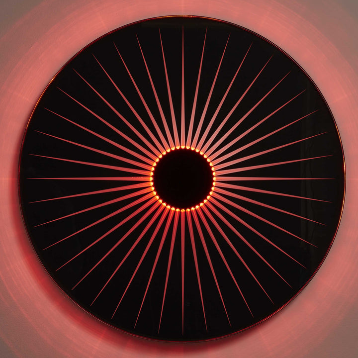 “Iris” by Ben Rousseau – a circular illuminated artwork crafted from engraved acrylic, combining nature’s geometry with digital precision. Red and amber light radiates from the centre, evoking the structure of a human iris in sculptural form.

