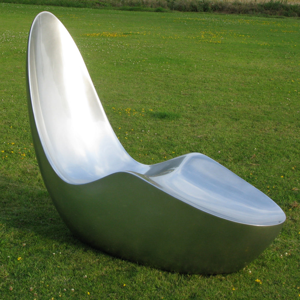 “Caillou Chaise – Metallic Wet Spray” by Ben Rousseau – a sculptural chaise inspired by 1960s grand tourers, hand-shaped in composite with a high-gloss metallic lacquered finish in white, lime, gold, or silver. A fusion of luxury design and form.

