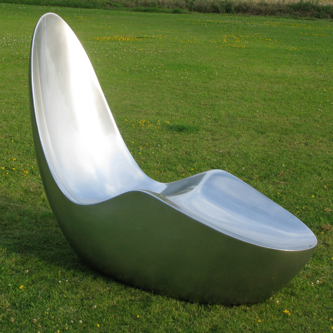 “Caillou Chaise – Metallic Wet Spray” by Ben Rousseau – a sculptural chaise inspired by 1960s grand tourers, hand-shaped in composite with a high-gloss metallic lacquered finish in white, lime, gold, or silver. A fusion of luxury design and form.

