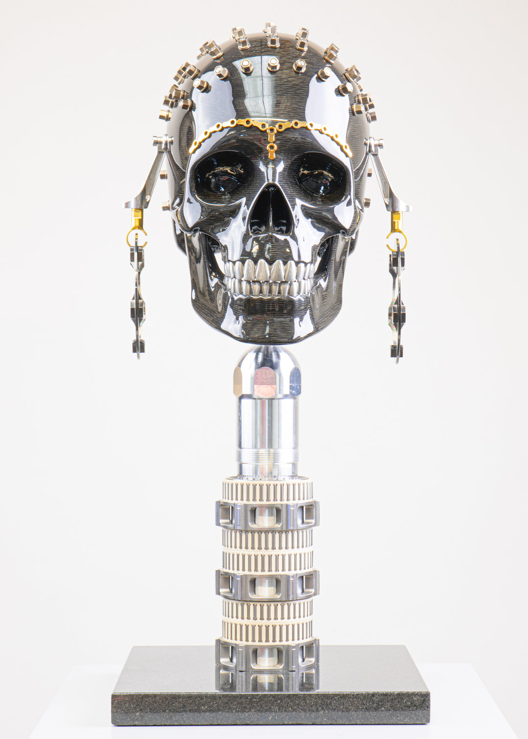 Alastair Gibson CarbonArt45 carbon fibre skull sculpture with high-gloss finish, Formula One components, stainless steel bolt crown detail, gold-plated accents and precision-engineered metal base