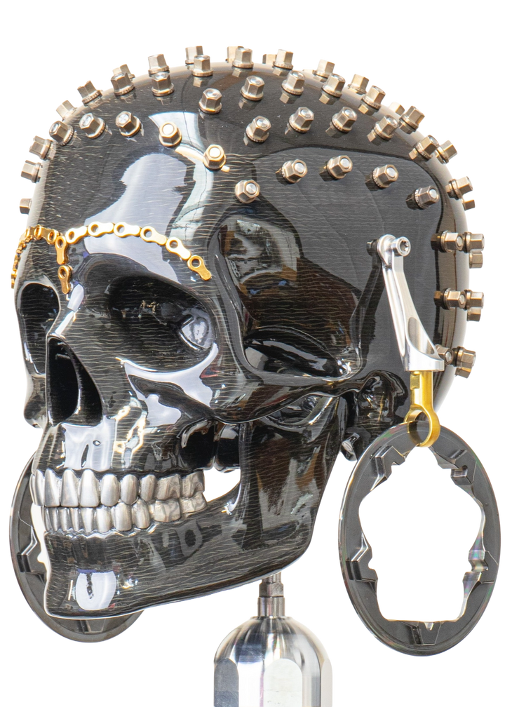 Alastair Gibson CarbonArt45 carbon fibre skull sculpture with high-gloss finish, Formula One components, stainless steel bolt crown detail, gold-plated accents and precision-engineered metal base