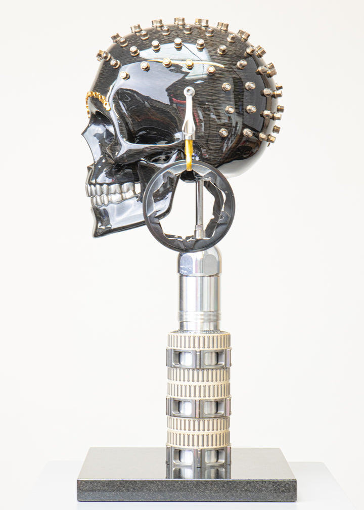 Alastair Gibson CarbonArt45 carbon fibre skull sculpture with high-gloss finish, Formula One components, stainless steel bolt crown detail, gold-plated accents and precision-engineered metal base