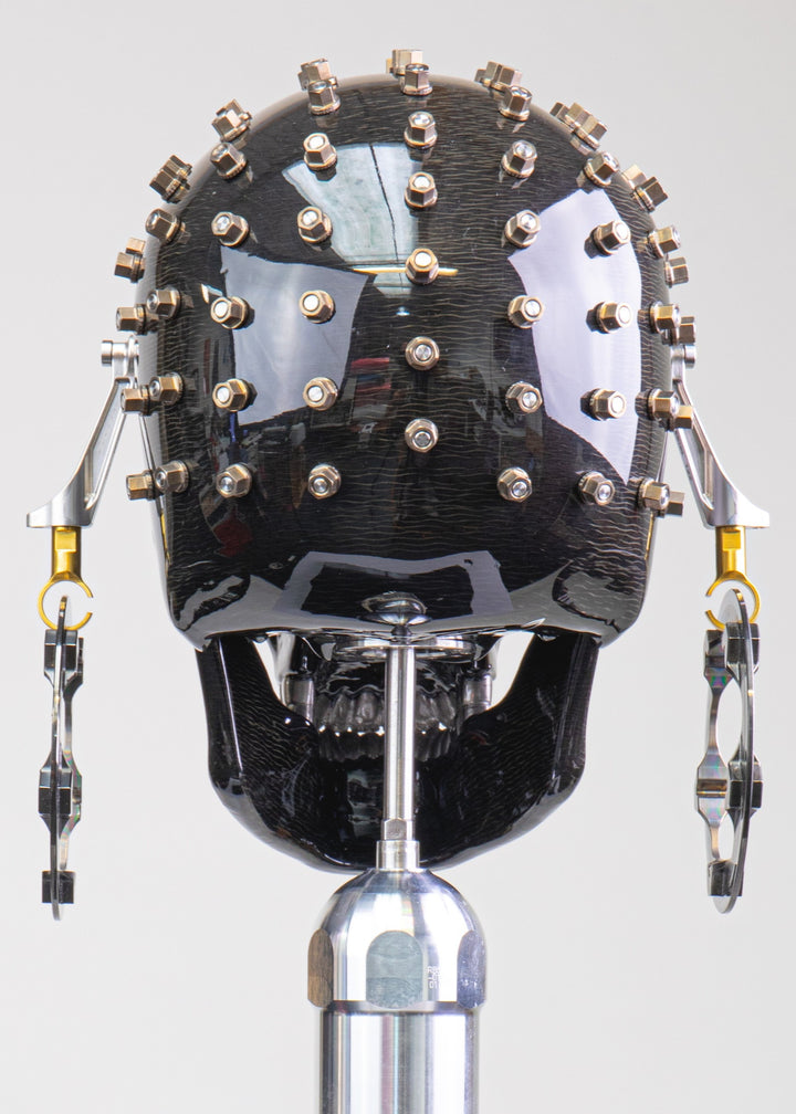 Alastair Gibson CarbonArt45 carbon fibre skull sculpture with high-gloss finish, Formula One components, stainless steel bolt crown detail, gold-plated accents and precision-engineered metal base