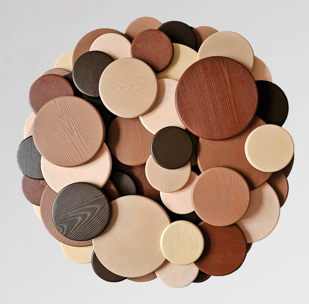 Wall sculpture made of layered wooden discs in various natural tones and wood grains, arranged in a circular cluster.
