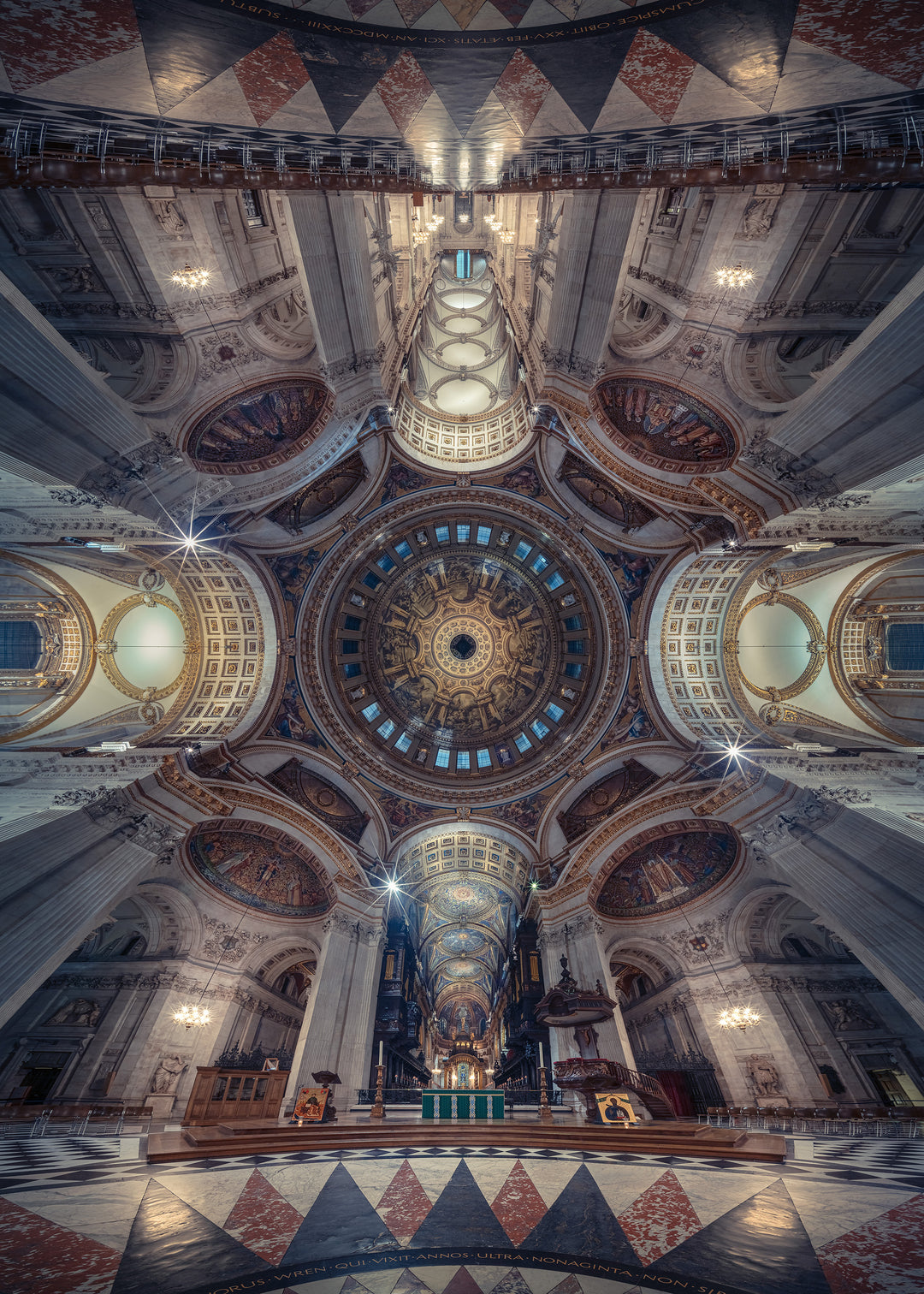 Panoramic photograph of St. Paul’s Cathedral interior, looking directly upward into the ornate dome designed by Sir Christopher Wren. The composition reveals gilded detailing, frescoes, marble arches, and the engineering mastery of the Whispering Gallery, captured in dramatic symmetry and ambient light.