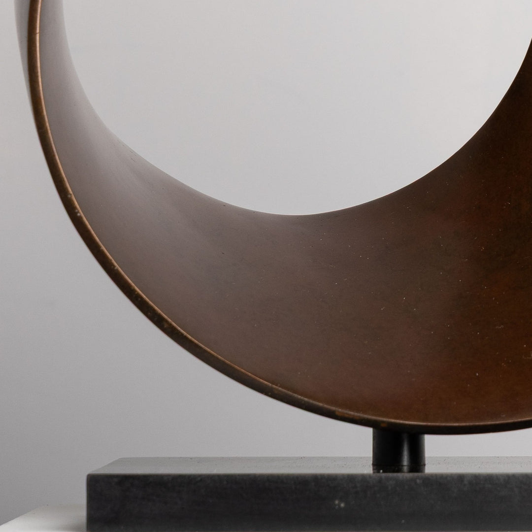 Patinated bronze Continuum sculpture by James Parker, formed as a flowing Möbius loop with a continuous twisting surface and crescent-like profile.