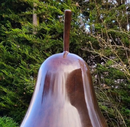 Patinated bronze Pear sculpture by James Parker, with a smooth refined surface, natural stem and generous organic form symbolising abundance, balance and longevity.