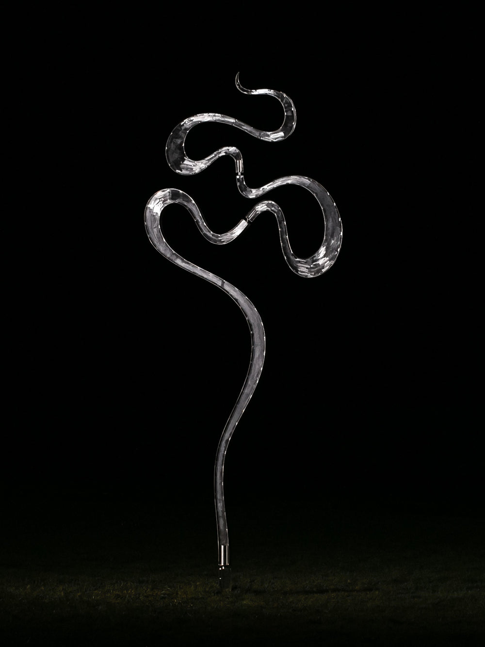 Abstract stainless steel kinetic sculpture featuring fluid, serpentine curves that shift gently with the wind