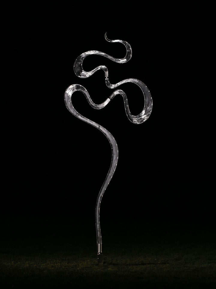 Abstract stainless steel kinetic sculpture featuring fluid, serpentine curves that shift gently with the wind