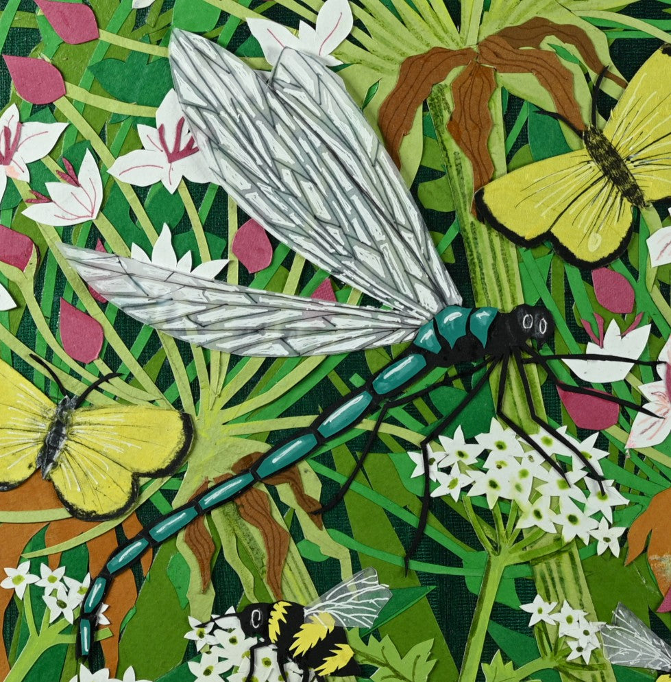 Cut-paper artwork featuring dragonflies, butterflies and bees in a dense summer meadow of white, pink and green botanical forms; layered coloured papers create a lively, intricate composition full of movement and detail.