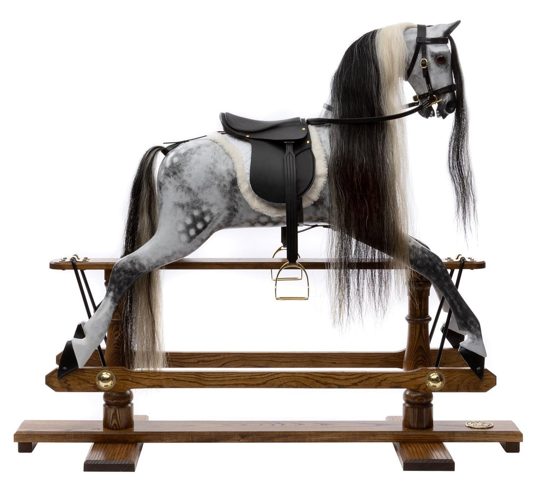 Hand-painted dapple grey rocking horse with long black and white mane, black leather saddle, and oak safety stand.

