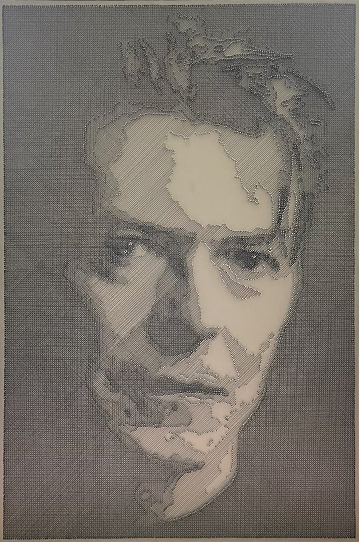 Portrait of David Bowie constructed from fine black enamelled copper wire tensioned around thousands of small metal nails on a silver acrylic painted board, forming dense linear layers that define facial features, hair and expression through tonal variation, depth and shadow across a rigid rectangular surface.