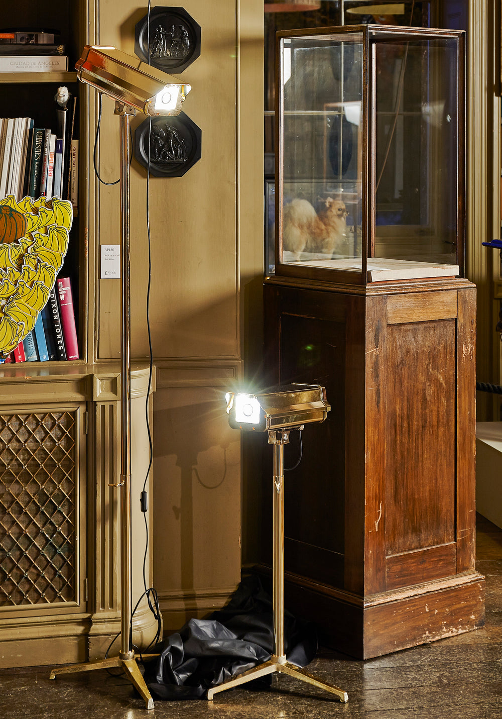 “CCTV Lights – Desk Top” by Ben Rousseau – a sculptural gold-plated LED lamp on a tripod base, reimagining the CCTV camera as a symbol of modern luxury and design. A provocative fusion of technology, art, and illumination.

