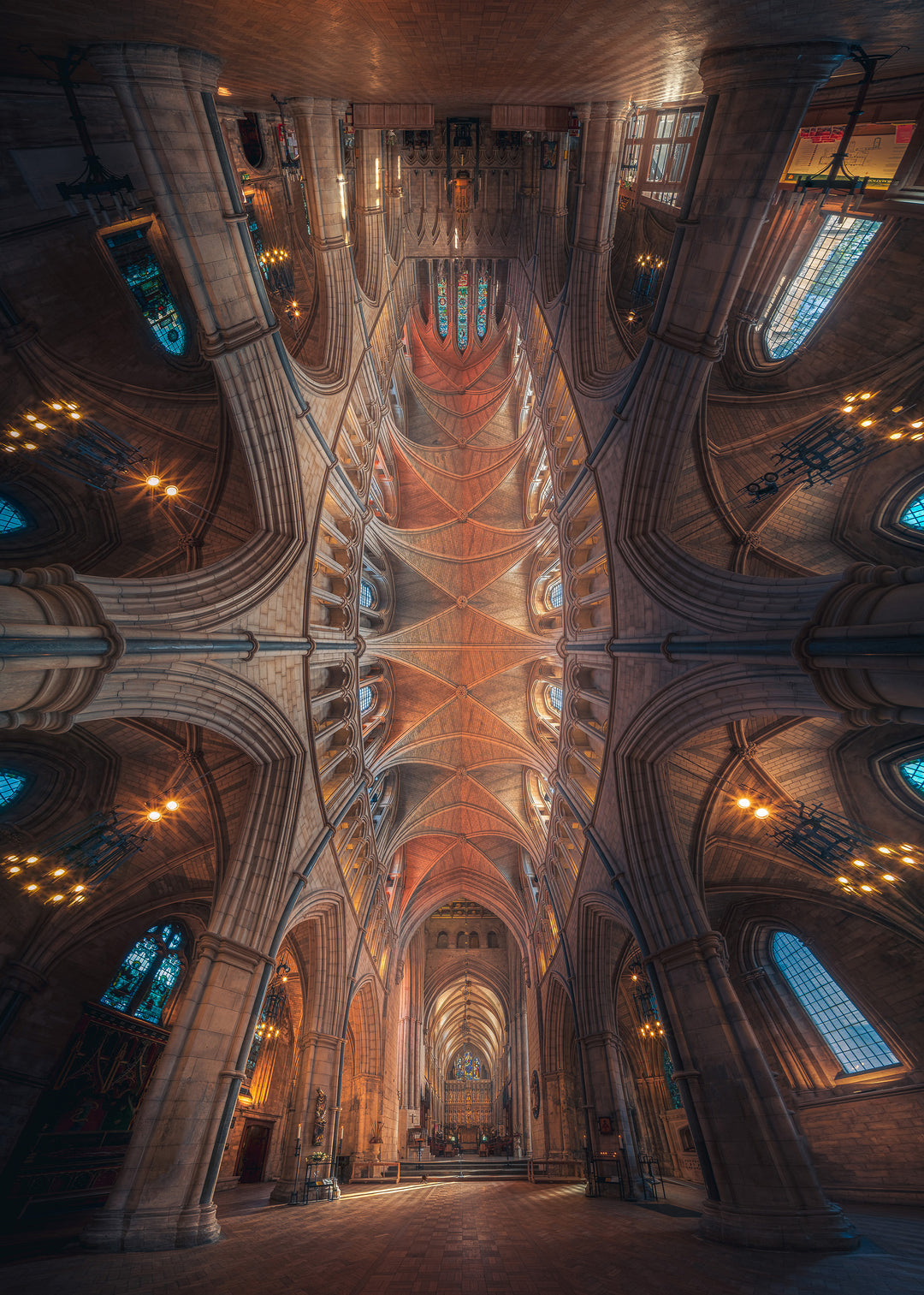 Vertical panoramic photograph of Southwark Cathedral’s nave showing soaring ribbed vaults, pointed arches, chandeliers and stained-glass windows leading to the high altar; a tranquil, symmetrical view dedicated to Doorkins, the cathedral’s beloved resident cat.
