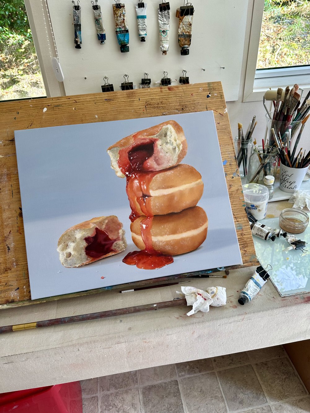 Hyperrealist painting of stacked jelly doughnuts with vivid red jam oozing down the sides