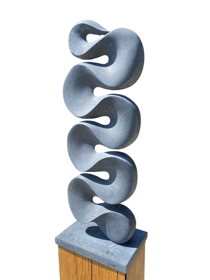 Abstract stone sculpture Ebb & Flow – 2025 by Hamish Holman, carved in deep grey Kilkenny limestone with a tall vertical form of flowing wave-like curves, smooth polished surface with subtle flecks of light grey, mounted on a stone base.