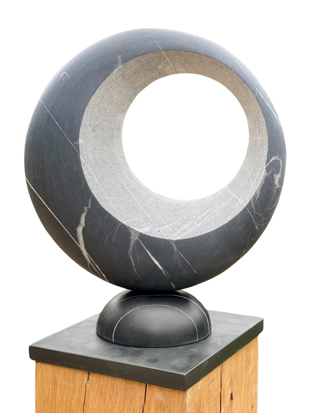 Abstract stone sculpture Eclipse – 2025 by Hamish Holman, carved from Nero Blue marble with a smooth circular form and hollowed centre, featuring natural white veining and a polished dark blue-grey surface, mounted on a wooden plinth.