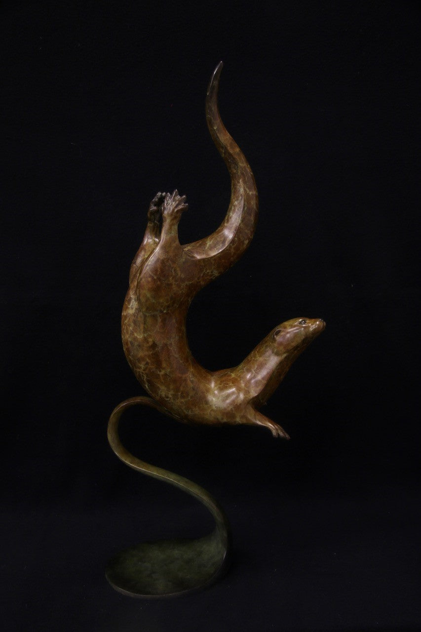 Bronze sculpture of a single otter diving with fluid, spiral movement, set against a black background.