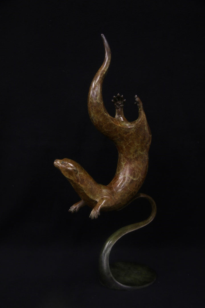 Bronze sculpture of a single otter diving with fluid, spiral movement, set against a black background.