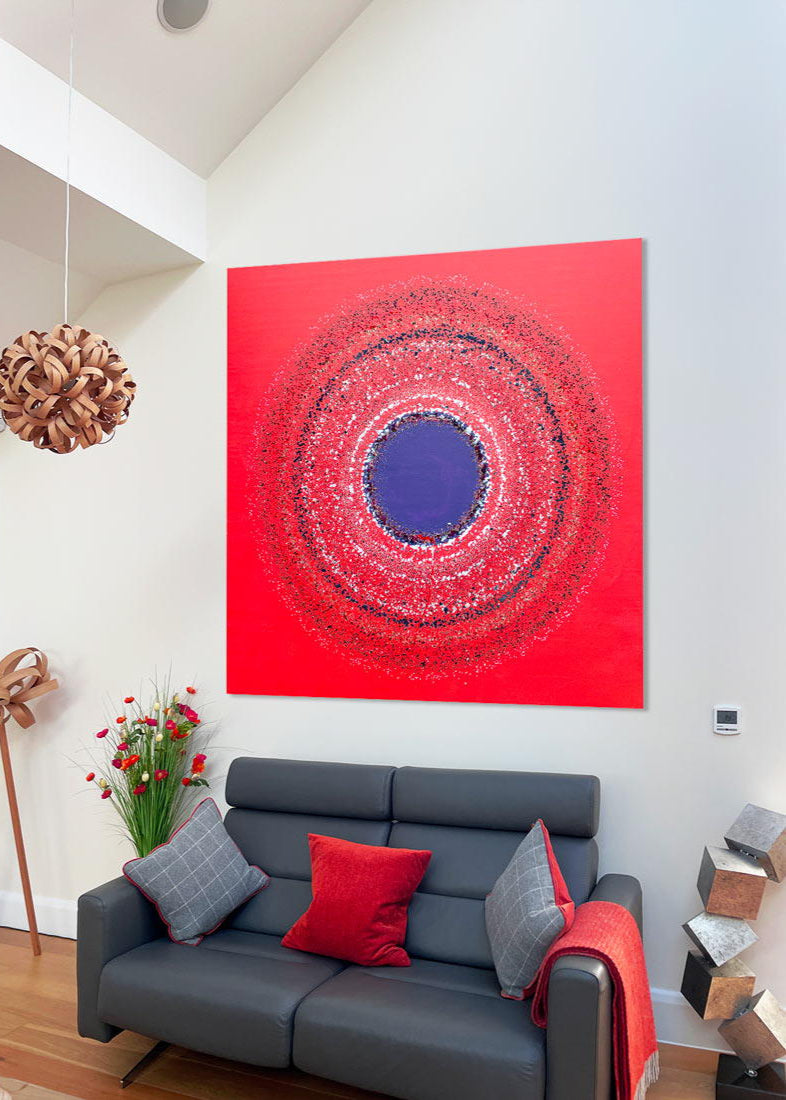 Large abstract painting “Ellipsis” by Swarez — bold square composition with a deep violet central circle surrounded by concentric rings of paint droplets and splashes on a vivid matte red background. Energetic, dynamic halo effect created by spin technique.