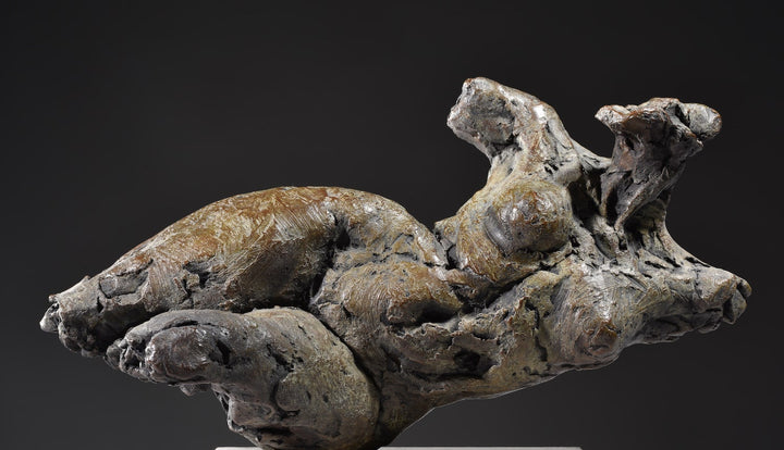 ‘Nude Emergence Torso’ by Hamish Mackie, a limited-edition contemporary bronze figurative sculpture depicting a fragmented reclining female nude torso. Inspired by ancient sculptural artefacts, the abstracted human form features rough, expressive modelling, weathered surfaces and an earthy brown bronze patina. Mounted horizontally on a rectangular Ancaster Weatherbed stone plinth, the sculpture explores the natural beauty and tactile qualities of the female form.