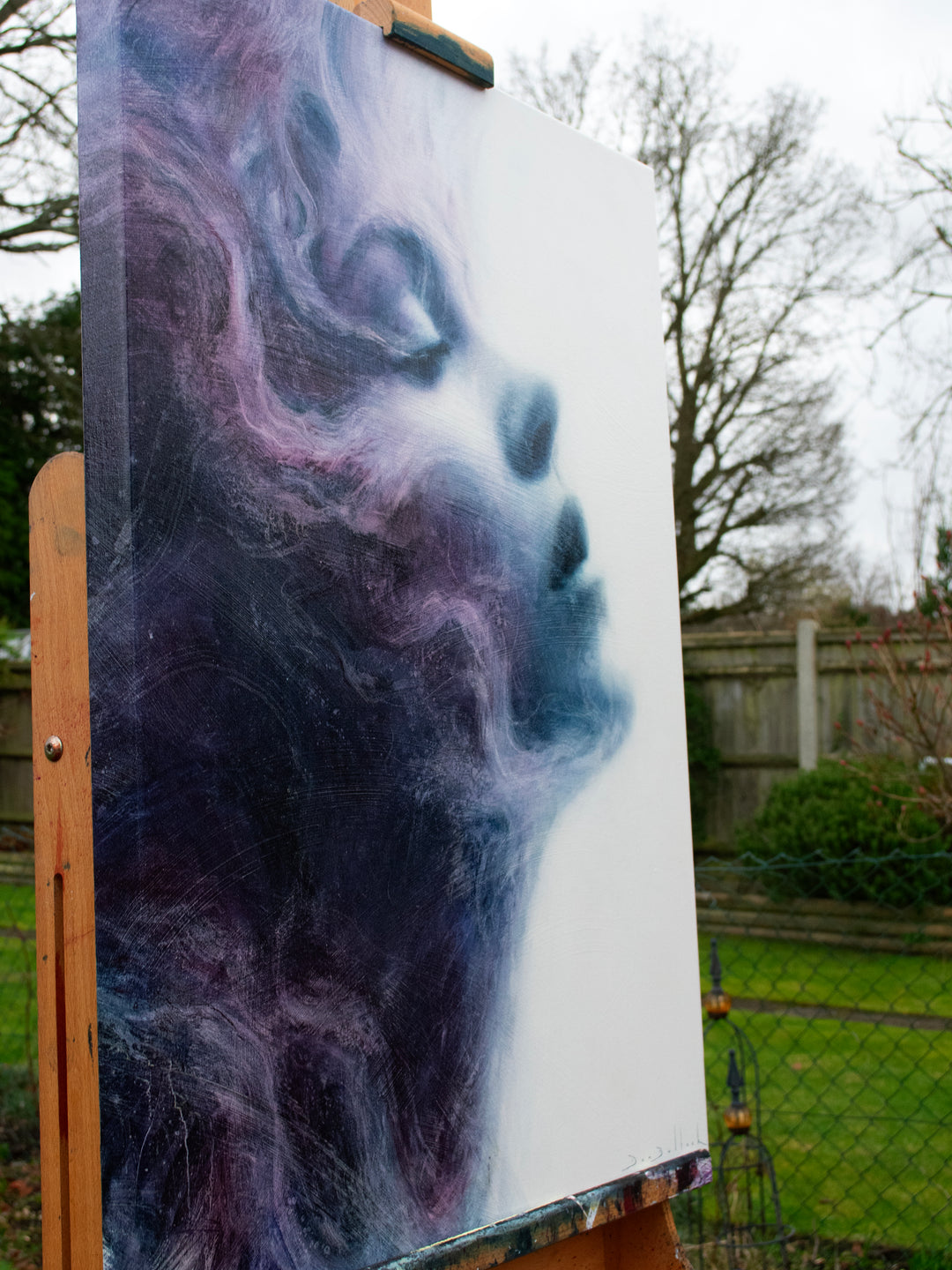 Oil on canvas painting by Dan Bullock, titled Eternal. A dreamlike portrait of a woman’s face in profile, eyes closed, emerging from swirling textures of deep indigo, violet, and soft lavender. The ethereal brushwork gives the impression of smoke or mist, creating a sense of serenity, timelessness, and transcendence.