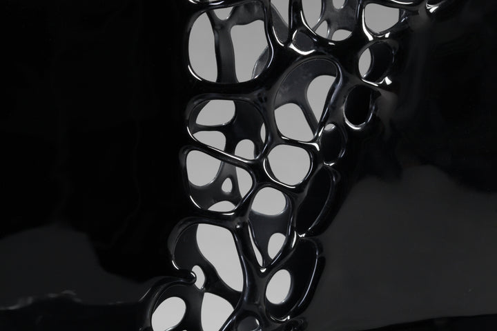 Tracy Nicholls glass sculpture Ethereality — a one-off kiln-formed artwork of opaque black glass with lace-like webbing that dissolves into open apertures. Standing on a granite and metal base, the intricate strands create depth and movement, while light filters through the perforations to cast shifting shadows.