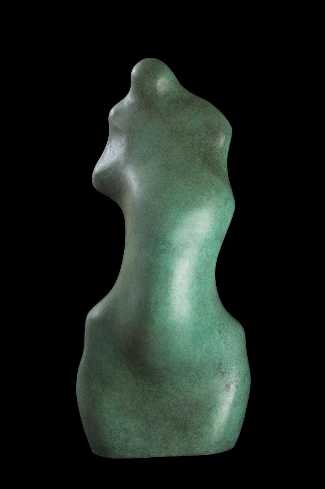 Bronze sculpture of an abstract female torso by Nicola Godden, with smooth organic curves and a softly polished surface, standing on a plinth outdoors against a clear blue sky, the form evoking the human body through simplified, flowing contours and natural balance.