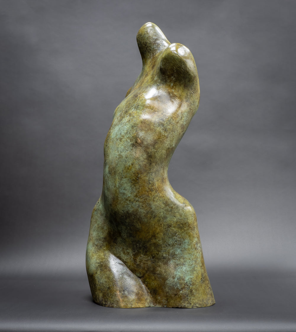 Bronze abstract female torso sculpture by Nicola Godden, with softly curved organic form and smooth hand-finished surface, standing on a plinth outdoors, evoking sensuality, balance and metamorphosis through simplified human anatomy and tactile patination.
