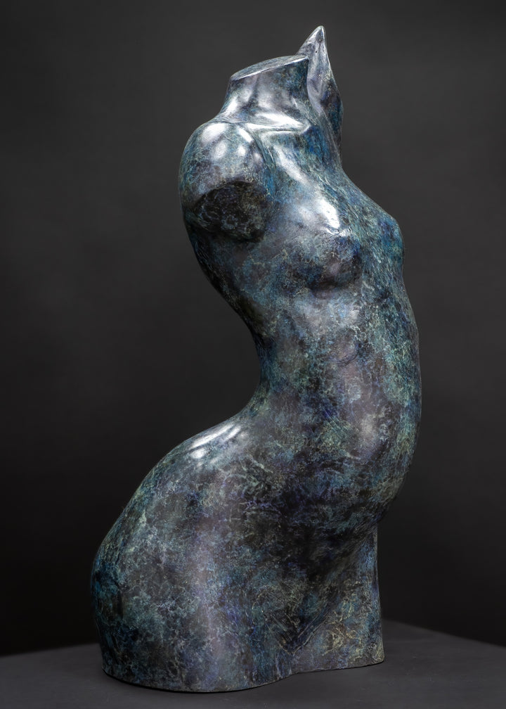 Abstract bronze female torso sculpture by Nicola Godden with flowing organic curves and a polished blue-green patina, standing as a sensual contemporary figurative form designed for garden or exterior display.
