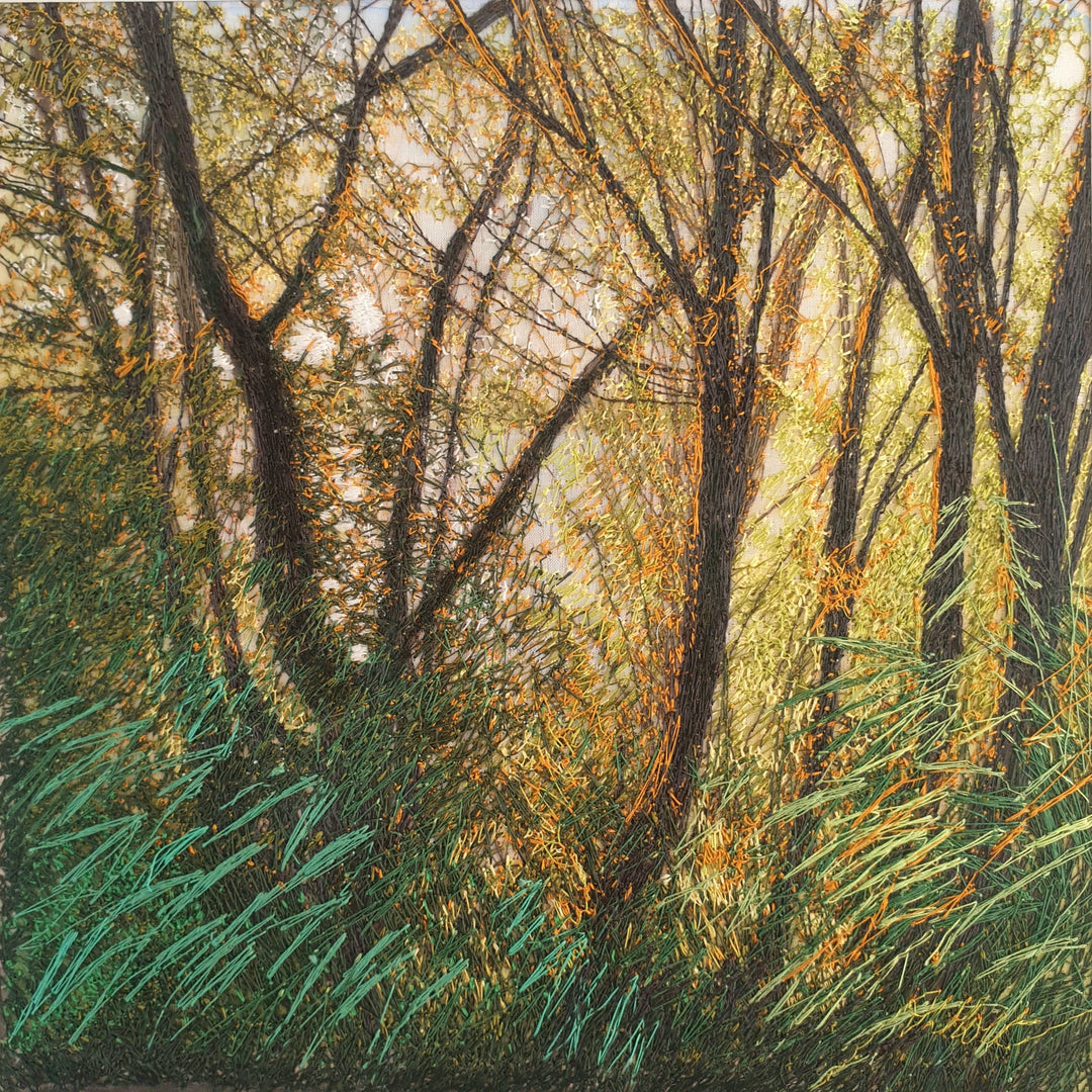 Embroidered woodland with tall trees, golden light filtering through branches, and vivid green and orange grasses in the foreground.
