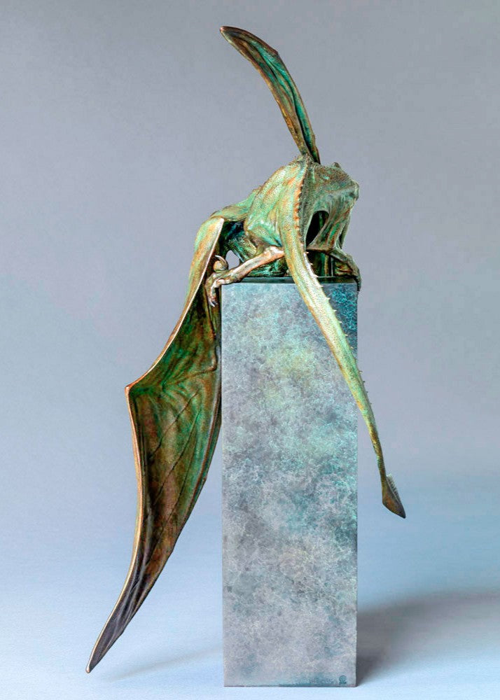 Bronze Firedrake dragon maquette by Nick Bibby, shown mid-leap with outstretched wings, spined tail and verdigris patina, blending anatomical realism with dramatic, creature-like detailing on a tall textured plinth.