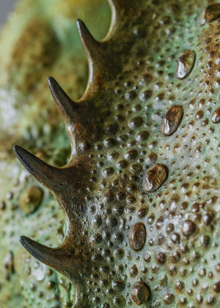 Bronze Firedrake dragon maquette by Nick Bibby, shown mid-leap with outstretched wings, spined tail and verdigris patina, blending anatomical realism with dramatic, creature-like detailing on a tall textured plinth.