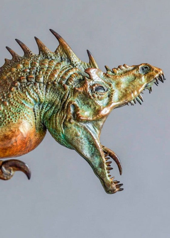 Bronze Firedrake dragon maquette by Nick Bibby, shown mid-leap with outstretched wings, spined tail and verdigris patina, blending anatomical realism with dramatic, creature-like detailing on a tall textured plinth.