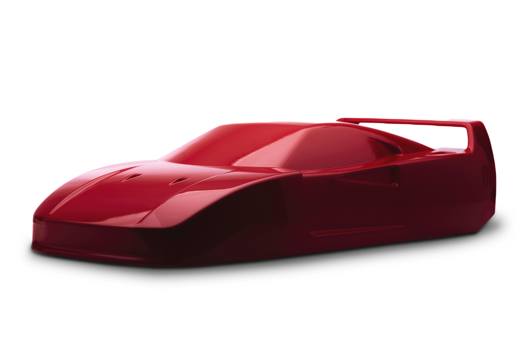 ‘Ferrari F40’ by Srini Gandra, a limited-edition contemporary automotive sculpture from the Forme di Velocità series, inspired by the legendary Ferrari F40, the final Ferrari personally approved by Enzo Ferrari. Presented in a striking high-gloss Rosso Corsa red finish, the sculpture captures the supercar's low wedge-shaped profile, sculpted bonnet, aerodynamic side intakes, distinctive rear engine vents and iconic elevated rear wing. Its smooth, minimalist surfaces celebrate the raw performance, aerodynami