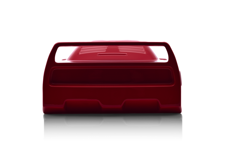 ‘Ferrari F40’ by Srini Gandra, a limited-edition contemporary automotive sculpture from the Forme di Velocità series, inspired by the legendary Ferrari F40, the final Ferrari personally approved by Enzo Ferrari. Presented in a striking high-gloss Rosso Corsa red finish, the sculpture captures the supercar's low wedge-shaped profile, sculpted bonnet, aerodynamic side intakes, distinctive rear engine vents and iconic elevated rear wing. Its smooth, minimalist surfaces celebrate the raw performance, aerodynami