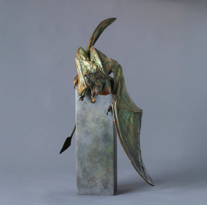 Bronze Firedrake dragon maquette by Nick Bibby, shown mid-leap with outstretched wings, spined tail and verdigris patina, blending anatomical realism with dramatic, creature-like detailing on a tall textured plinth.