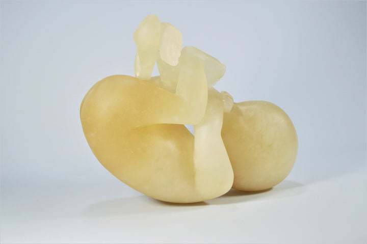 Deborah Harrison alabaster sculpture Foetus, one-off hand-carved work in translucent champagne alabaster, depicting a curled unborn child in the womb-like position, with soft organic form and warm golden glow, symbolising life, vulnerability, and spiritual beginnings.