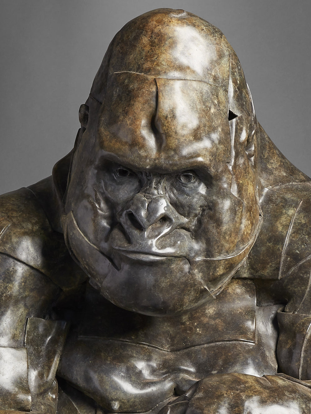 Monumental bronze sculpture by Fred Gordon titled Silverback Gorilla. The piece depicts a life-size gorilla in a crouched position, its powerful form captured with layered, faceted bronze planes that emphasise both strength and vulnerability. The textured patina ranges from deep bronze to subtle green undertones, highlighting the gorilla’s muscular presence and expressive face. At 110cm tall, this signed and numbered limited edition of 9 embodies Gordon’s mastery in wildlife sculpture.