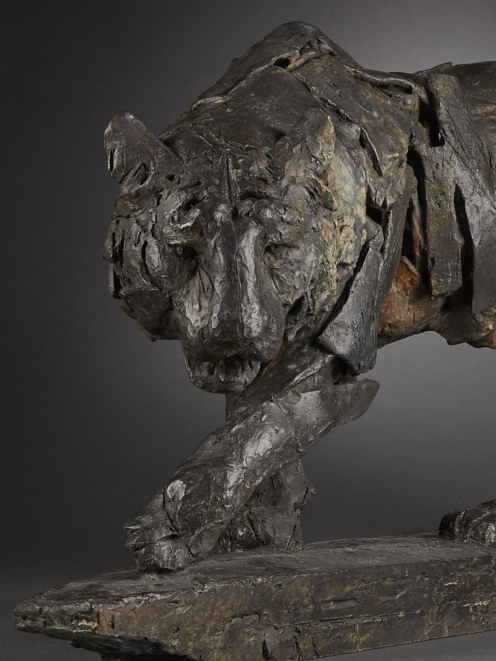 Limited edition bronze sculpture of a walking tiger by Fred Gordon. The piece shows the tiger mid-stride, muscles and movement captured through layered bronze planes that give a sense of both strength and fluidity. Rich dark patinas with earthy highlights emphasise the texture of the bronze, evoking the raw power and grace of this endangered predator. Signed and numbered in an edition of 12, the sculpture blends realism with abstraction, making it a striking wildlife artwork.
