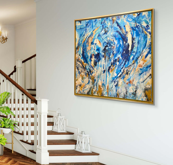 Highly textured blue and gold abstract painting with sweeping circular motion, cascading drips and layered brushstrokes, evoking water, movement and freedom, framed in a gold tray frame.