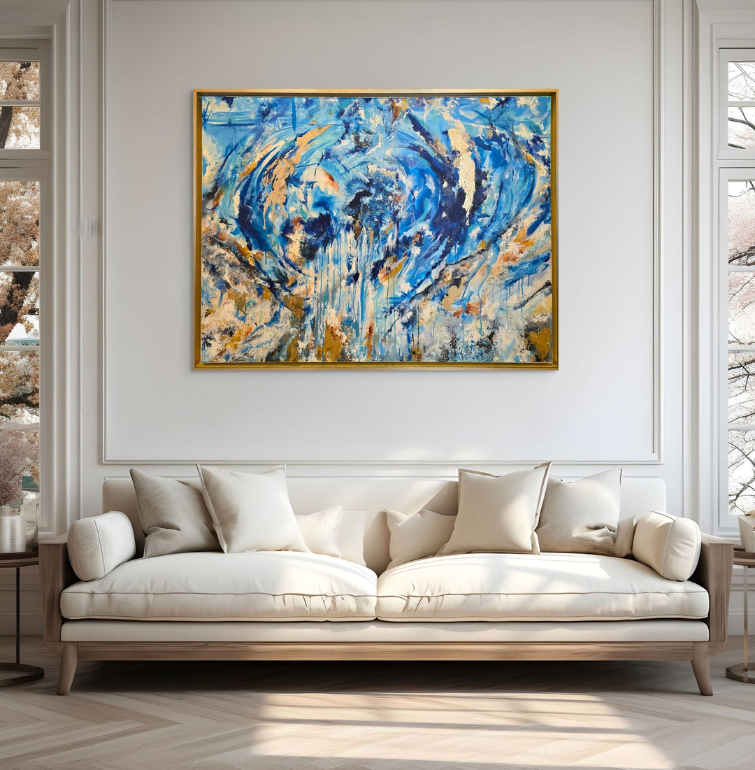 Highly textured blue and gold abstract painting with sweeping circular motion, cascading drips and layered brushstrokes, evoking water, movement and freedom, framed in a gold tray frame.