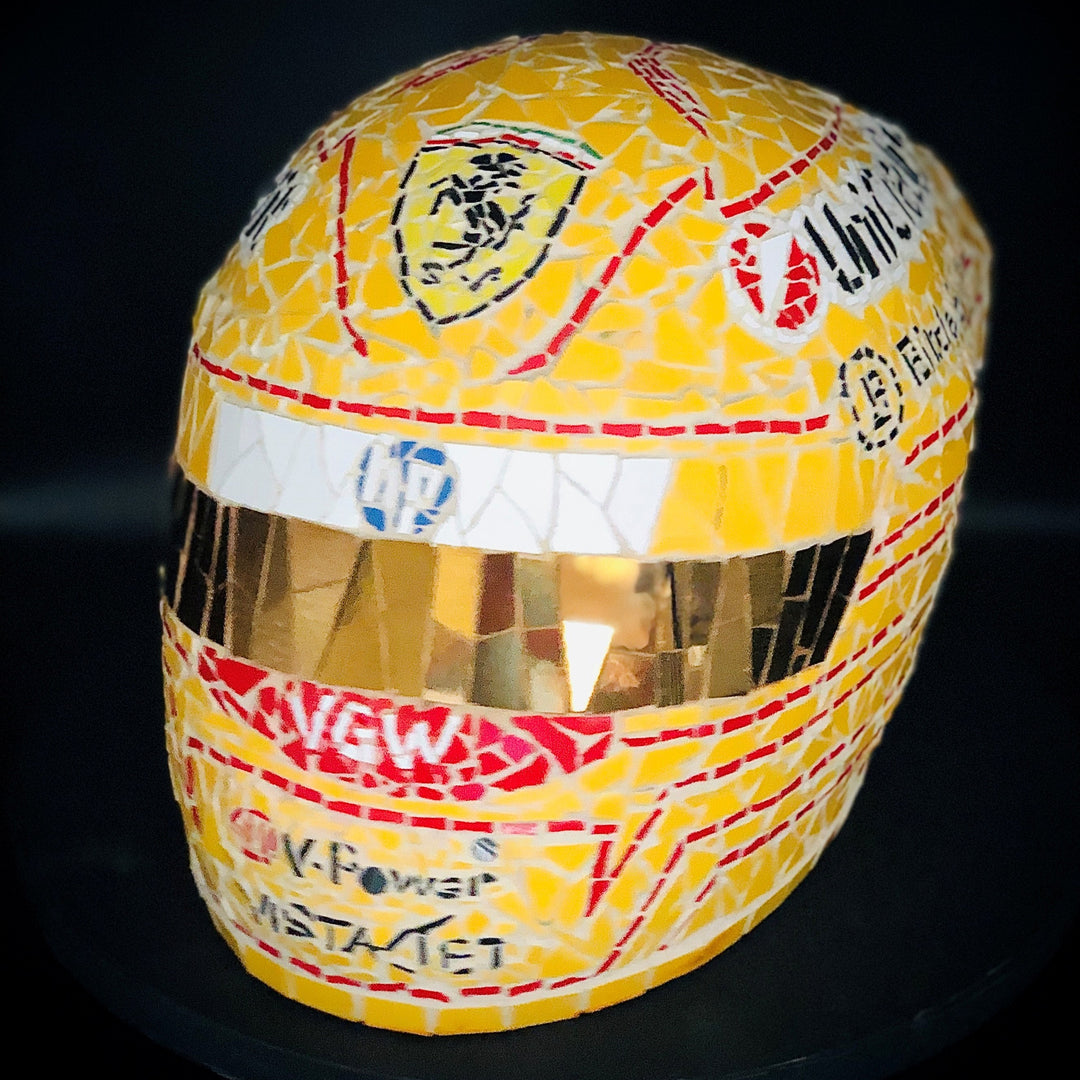 Full-size Ferrari-inspired Formula 1 helmet mosaic sculpture, handcrafted from individually cut ceramic tiles in red, yellow, white, black, and metallic gold. This bespoke artwork captures the energy and precision of motorsport design, created as an example of a custom commission.