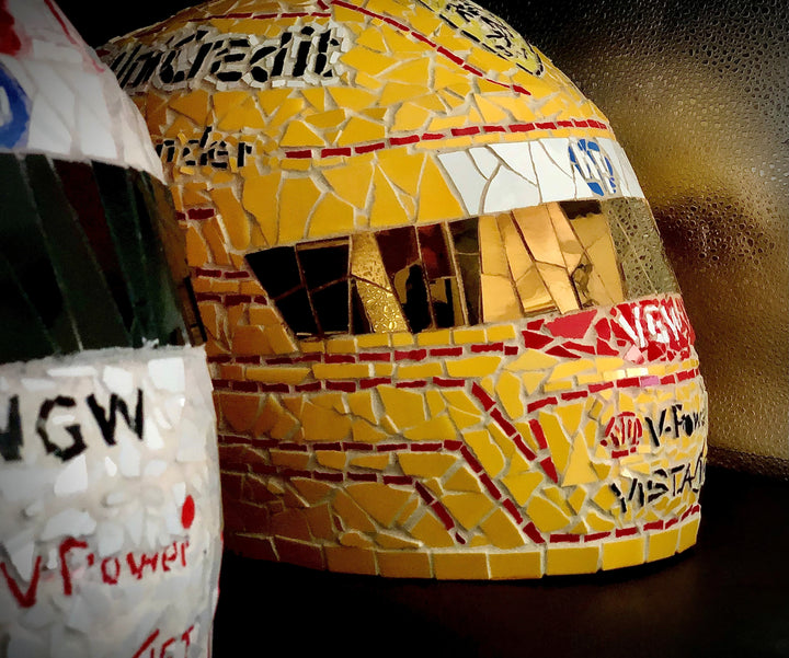 Full-size Ferrari-inspired Formula 1 helmet mosaic sculpture, handcrafted from individually cut ceramic tiles in red, yellow, white, black, and metallic gold. This bespoke artwork captures the energy and precision of motorsport design, created as an example of a custom commission.
