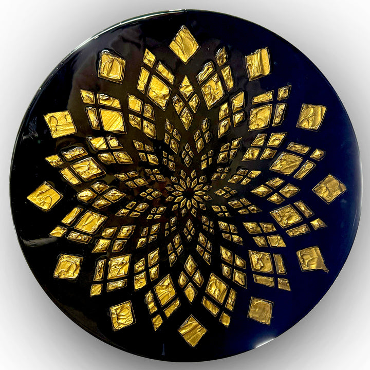 Bold circular wall artwork by Mike Philp with gold leaf geometric patterns radiating across a deep black ground. The high-gloss resin finish enhances light, depth, and precision, giving the piece a refined, architectural presence.