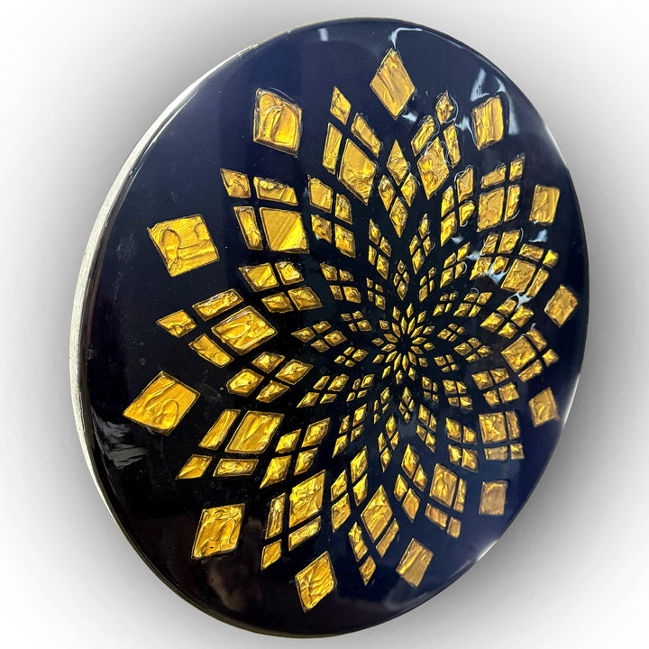Bold circular wall artwork by Mike Philp with gold leaf geometric patterns radiating across a deep black ground. The high-gloss resin finish enhances light, depth, and precision, giving the piece a refined, architectural presence.