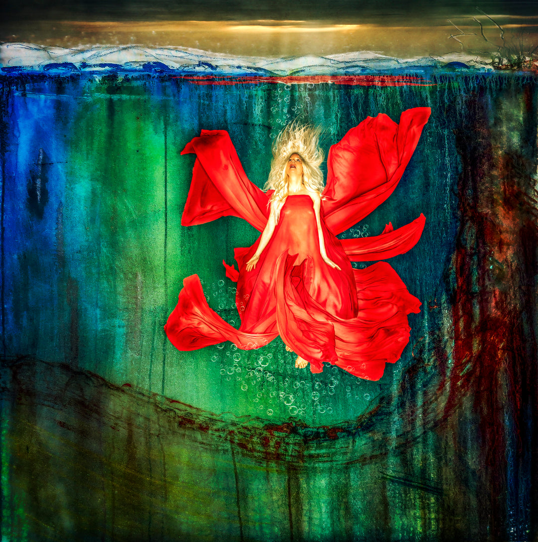 A dreamlike digital composition featuring artist Jayne Farleigh submerged underwater, her flowing red dress billowing like petals against a surreal backdrop of green and blue tones. Her blonde hair floats upward, eyes closed, evoking a sense of serenity and surrender. The surface glows faintly above, while painterly textures and light distortions give the image a haunting, immersive quality.