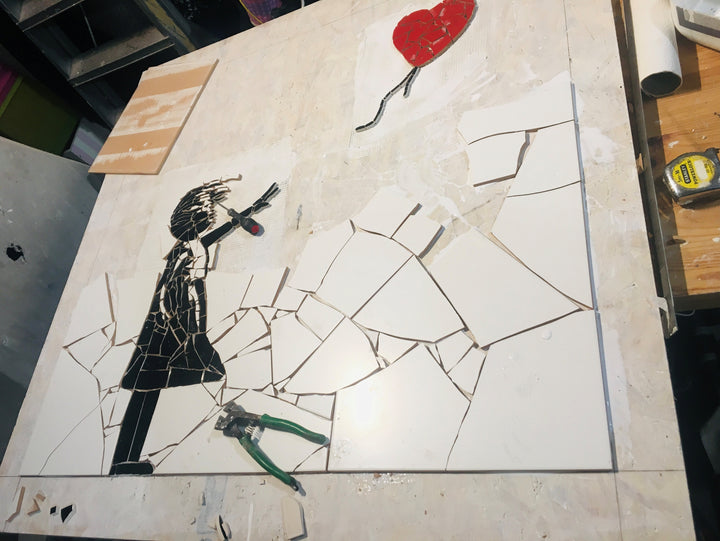 “Girl with Balloon” mosaic — a handcrafted ceramic tile artwork reimagining the iconic heart balloon image. Featuring black and white tiles with a vivid red heart, this bespoke commission blends street art symbolism with fine mosaic craftsmanship.