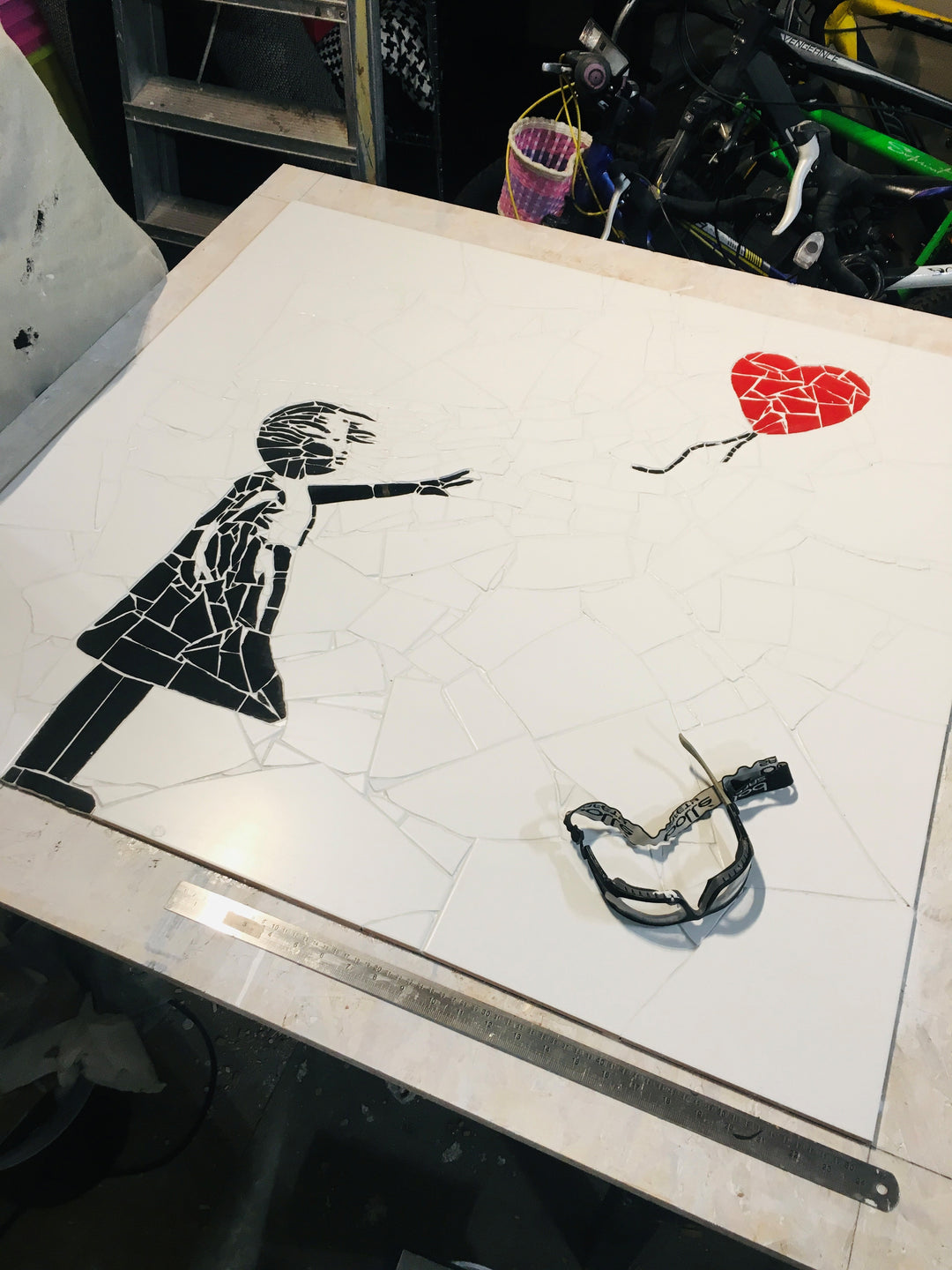 “Girl with Balloon” mosaic — a handcrafted ceramic tile artwork reimagining the iconic heart balloon image. Featuring black and white tiles with a vivid red heart, this bespoke commission blends street art symbolism with fine mosaic craftsmanship.